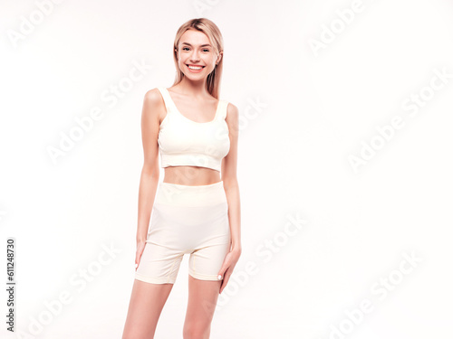 Young beautiful smiling blond female in summer cycling shorts clothes. Sexy carefree woman posing on white background in studio. Positive model having fun indoors. Cheerful and happy