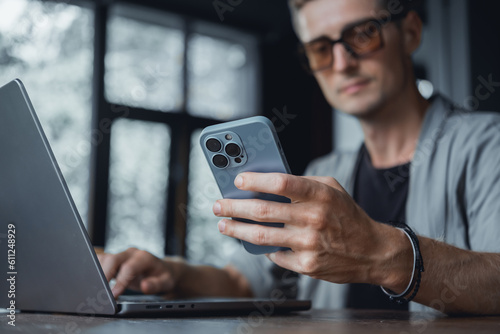 Young man using smartphone in hand, cafe, office,outdoor portrait business man, hipster style, internet, smartphone, office, Bali Indonesia, holding, mac OS, manager, freelancer, concept