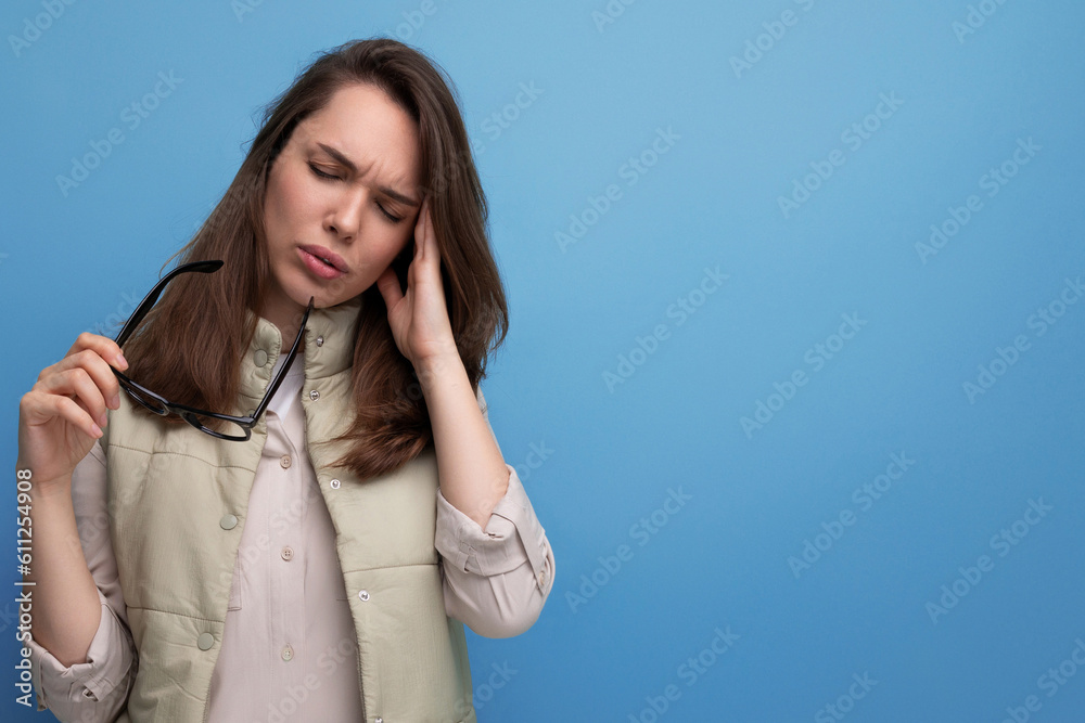 a young brunette woman took off her glasses for vision due to dryness in her eyes on a studio background with copy space a young brunette woman took off her glasses for vision due to dryness in her eyes on a studio background with copy space