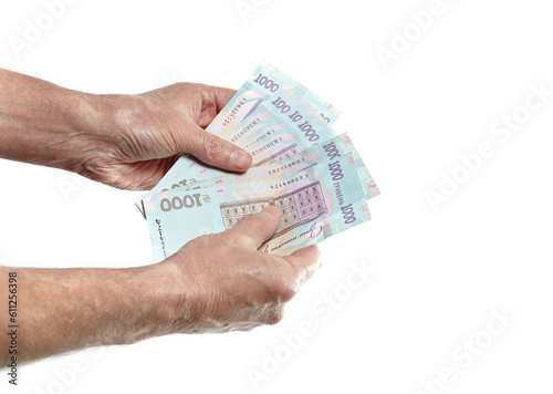 Men's hand holding ukrainian currency isolated on white background. A lot of 1000 hryvnia banknotes