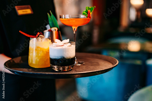 Sticker glasses alcohol cocktail set on a waiter tray in bar