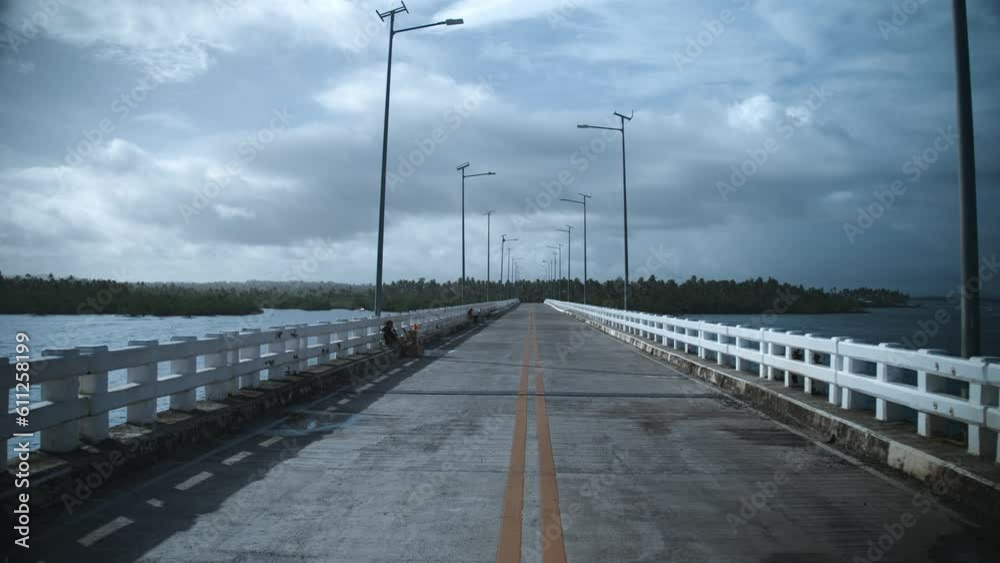 Walking down the sunset bridge on the island of Siargao in the Philippines Walking down the sunset bridge on the island of Siargao in the Philippines