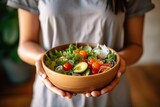 Healthy salad bowls held by Asian women in gym clothes to promote good health and wellness at home.;Generated with AI