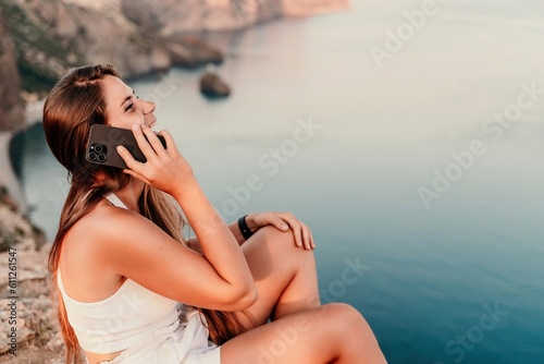 Sea phone Portrait of a happy woman on the background of the sea, dressed in white shorts and a T-shirt, long hair loose, talking on the phone
