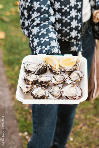 Woman shows oysters in Salamanca Markets, Tasmania, Australia
