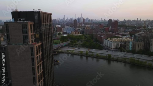 Aerial view passing a condo and over the Harlem river drive, toward the Manhattan skyline, sunset in NY photo