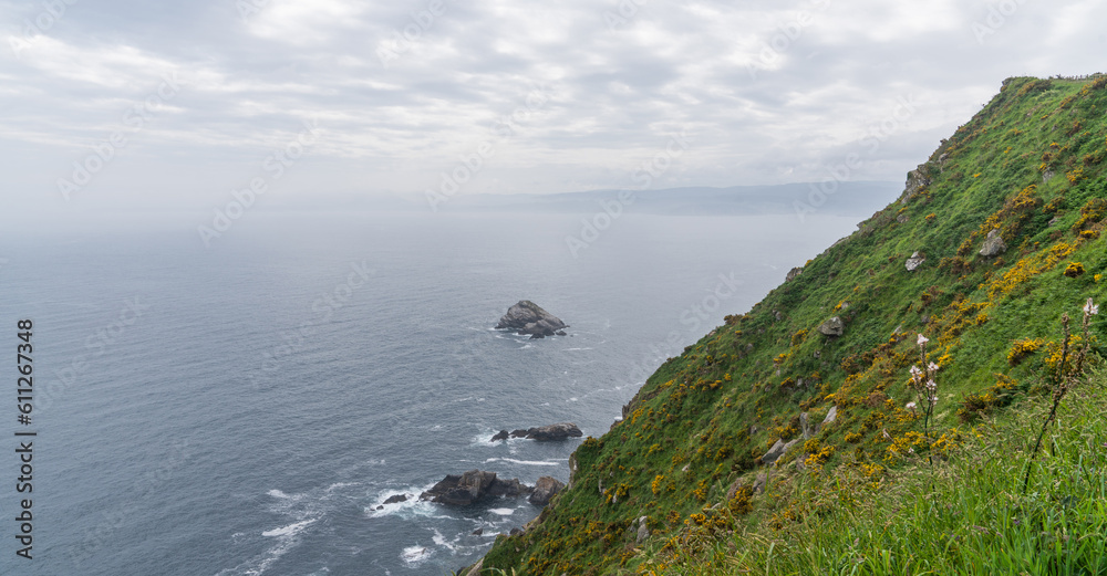 Fototapeta premium Nature landscape rocky cliff shore. Cabo Ortegal lighthouse with the sea in the background on the coast of Galicia, Spain, Europe. Majestic coastline looking the Atlantic Ocean.