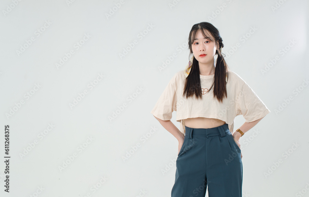 Portrait isolated cutout studio shot of Asian young cute female teenage fashion model with pigtails braids hairstyle in casual trendy wear standind posing look at camera on white background Portrait isolated cutout studio shot of Asian young cute female teenage fashion model with pigtails braids hairstyle in casual trendy wear standind posing look at camera on white background