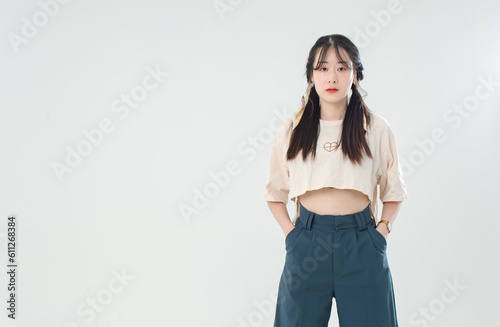 Portrait isolated cutout studio shot of Asian young cute female teenage fashion model with pigtails braids hairstyle in casual trendy wear standind posing look at camera on white background