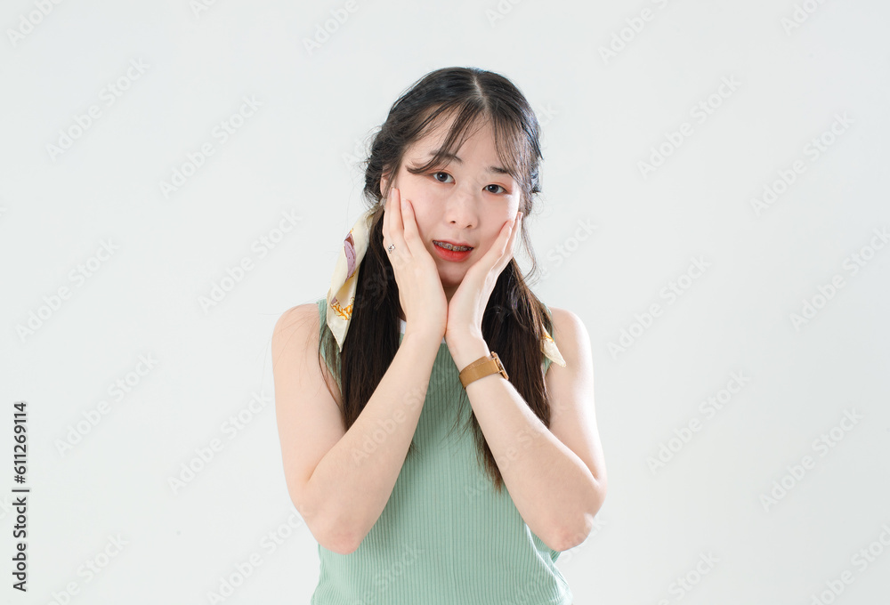 Portrait isolated cutout studio shot of Asian young cool female teenage fashion model with pigtails braids hairstyle in casual trendy shirt shorts standing posing look at camera on white background Portrait isolated cutout studio shot of Asian young cool female teenage fashion model with pigtails braids hairstyle in casual trendy shirt shorts standing posing look at camera on white background