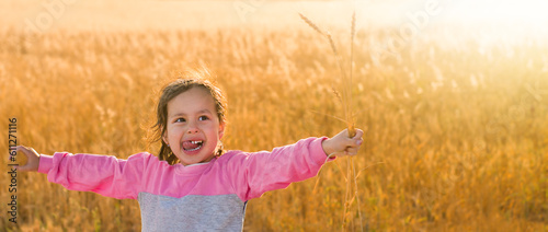 Joyful girl in the field with arms wide open photo