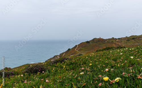 View of the Atlantic coast near the lighthouse in Cabo da Roca in Portugal. The westernmost point in Europe. Flowering spring coastal plants. photo