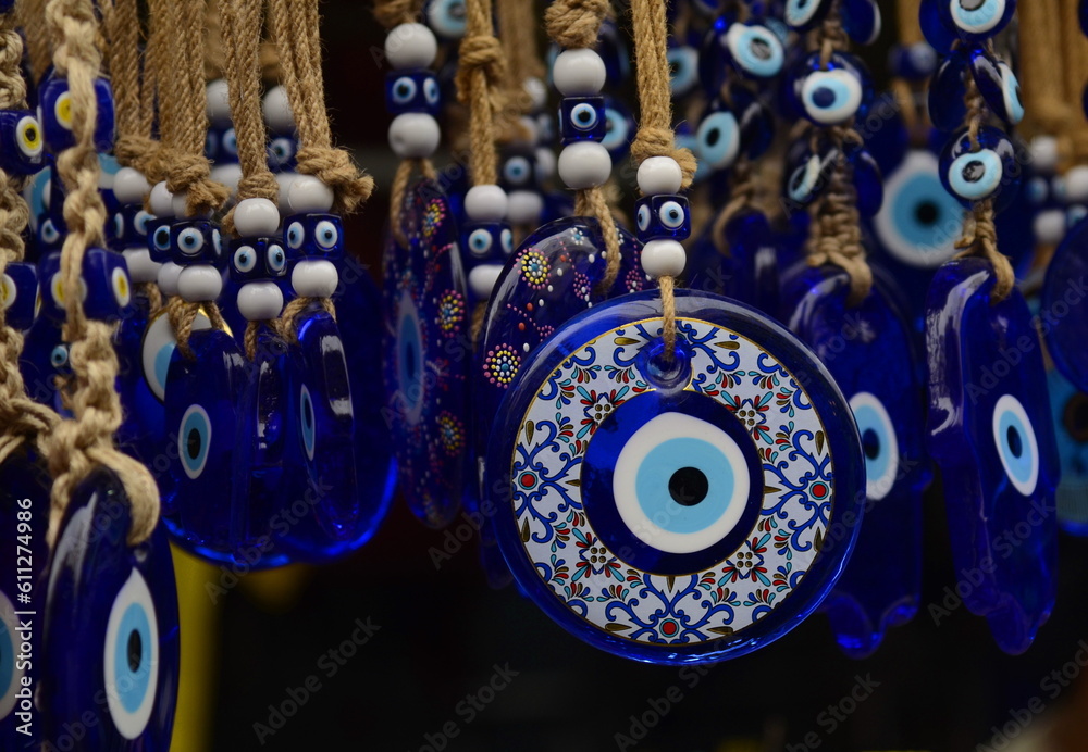 Nazar in market. Blue and red Fatima eye close-up protective amulet against evil eye. Israeli and turkish souvenir.  - obrazy, fototapety, plakaty 
