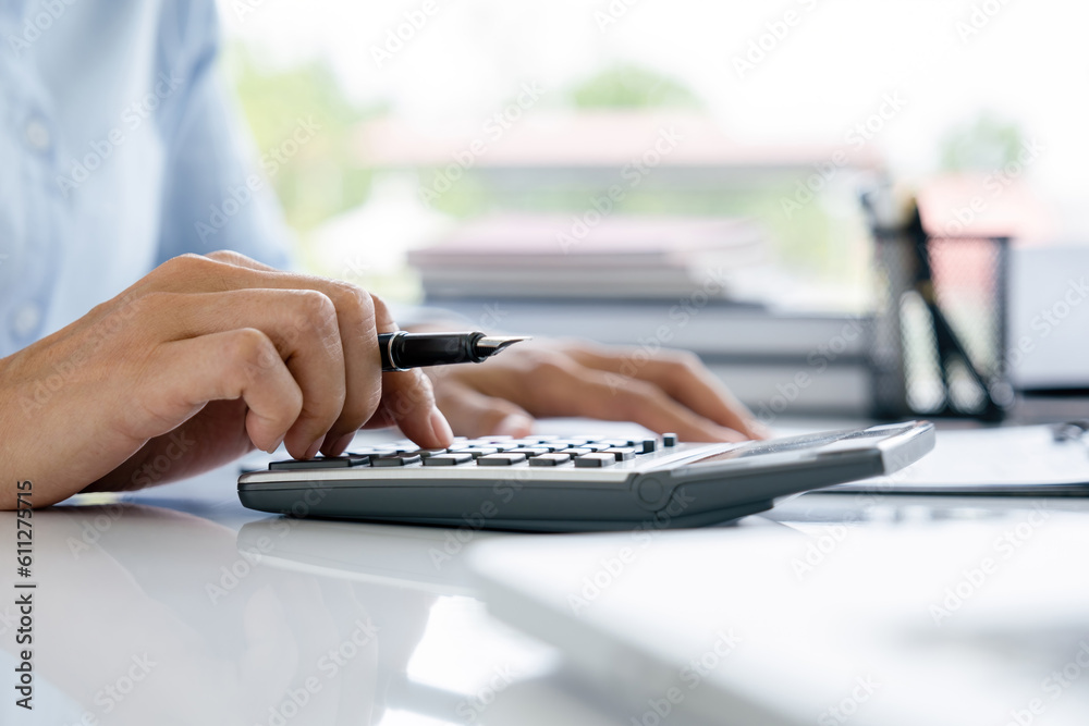 Obraz premium Woman working by using calculator.