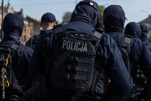 Polish Police officers keeping order in manifestation protest. Riot control squad, policeman on duty controlling a demonstration. Letters in Polish language, Policja means Police.