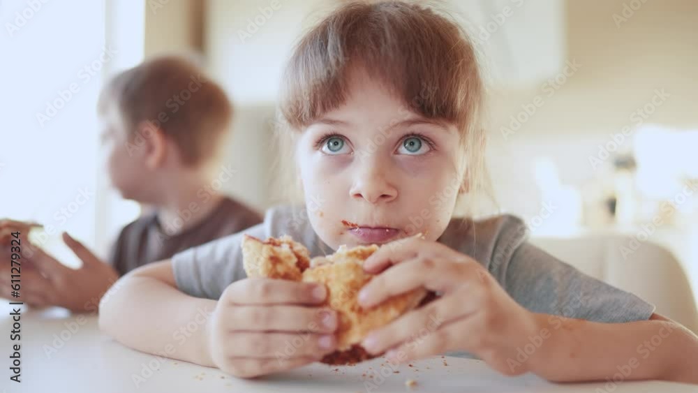 children eat burgers. fast food burger. a group of small children in the kitchen greedily eat fast food burgers. big family small kids having sun breakfast in the morning in the kitchen eating burger children eat burgers. fast food burger. a group of small children in the kitchen greedily eat fast food burgers. big family small kids having sun breakfast in the morning in the kitchen eating burger