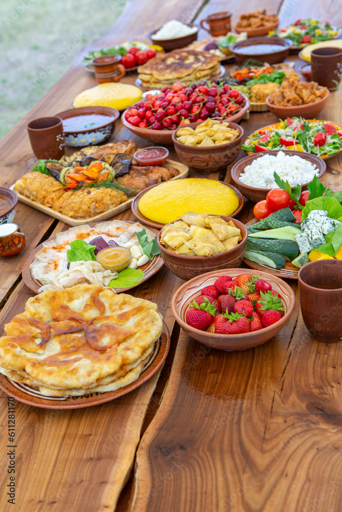 Homemade Romanian Food with grilled meat, polenta and vegetables Platter on camping. Romantic traditional moldavian food outside on the wood table.