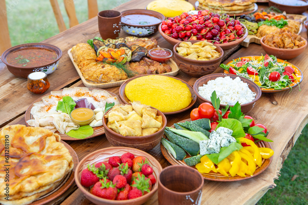 Homemade Romanian Food with grilled meat, polenta and vegetables Platter on camping. Romantic traditional moldavian food outside on the wood table. Homemade Romanian Food with grilled meat, polenta and vegetables Platter on camping. Romantic traditional moldavian food outside on the wood table.