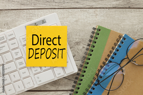 direct deposit text on yellow sticker on white keyboard. Business concept image photo