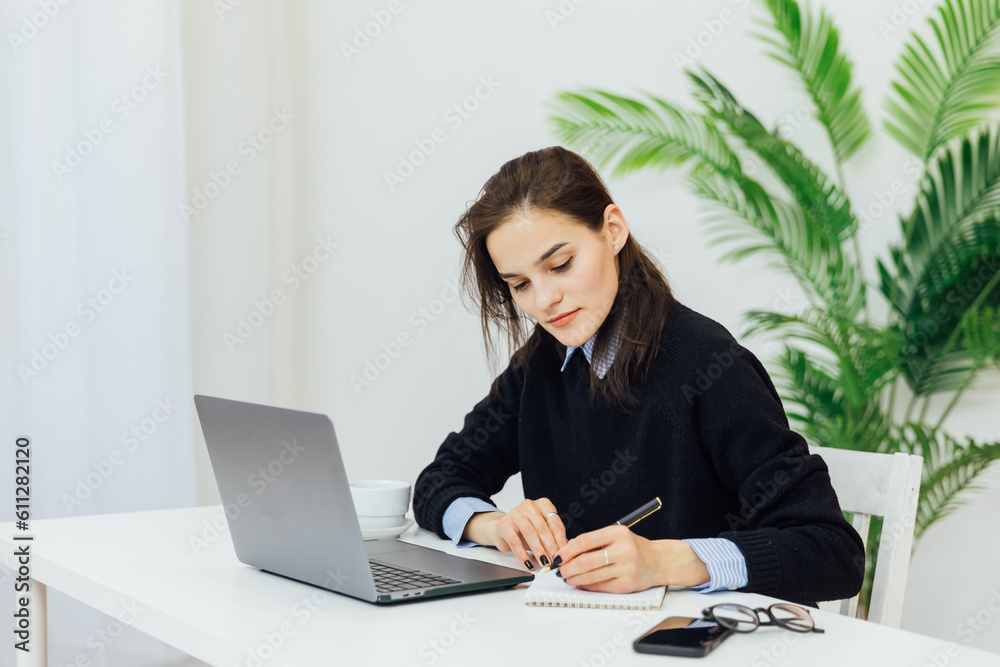 communication woman at the computer makes a note in a notebook remote work internet conversation online communication woman at the computer makes a note in a notebook remote work internet conversation online