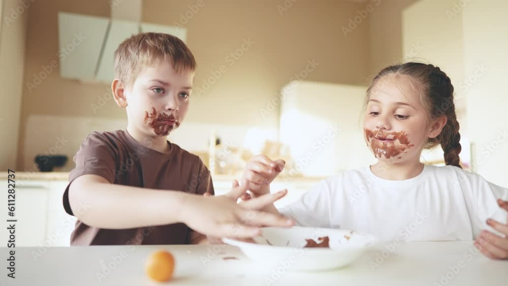 baby boy lifestyle and girl eat chocolate. dirty little baby kids in the kitchen eating chocolate in the morning. happy family eating sweets kid dream concept. baby dirty face eating chocolate cocoa baby boy lifestyle and girl eat chocolate. dirty little baby kids in the kitchen eating chocolate in the morning. happy family eating sweets kid dream concept. baby dirty face eating chocolate cocoa