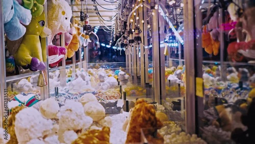 kids playing claw crane game and trying to take a toy. Using the crane hand and take a gift. Fun for the whole family at fairs and amusement parks