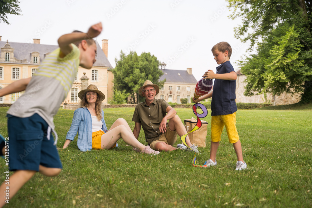 Obraz premium Happy harmonious family of mother, grandfather and two little boys having activities together