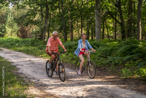 Full length view of the people riding bicycle in the forest road