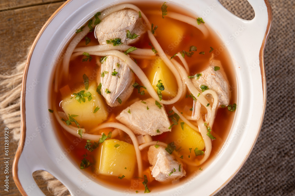 Delicious traditional romanian soup with pork meat, vegetables and noodles. Horizontal top view. Delicious traditional romanian soup with pork meat, vegetables and noodles. Horizontal top view.