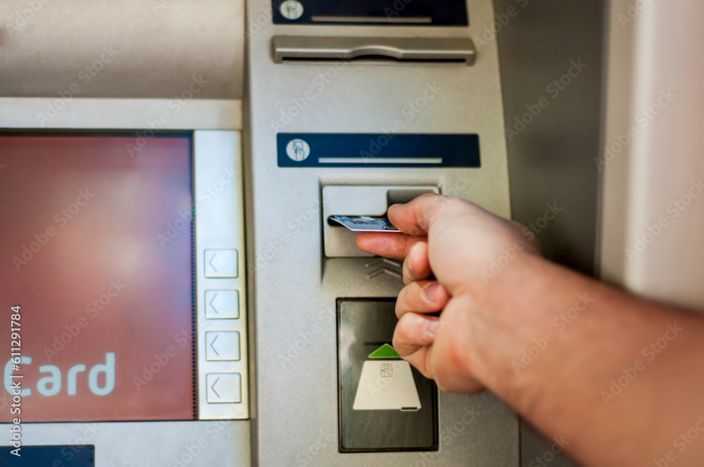 Hand of a man with a credit card, using an ATM. Man using an atm machine with his credit card. Hand of a man with a credit card, using an ATM. Man using an atm machine with his credit card.