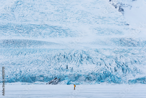  traveler finds himself detained in an impressive landscape of ice inside the Vatnajokull National Park, in Iceland. The dazzling ice formations and intricate patterns reveal the magnificent beauty o