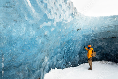  traveler finds himself detained in an impressive landscape of ice inside the Vatnajokull National Park, in Iceland. The dazzling ice formations and intricate patterns reveal the magnificent beauty o photo