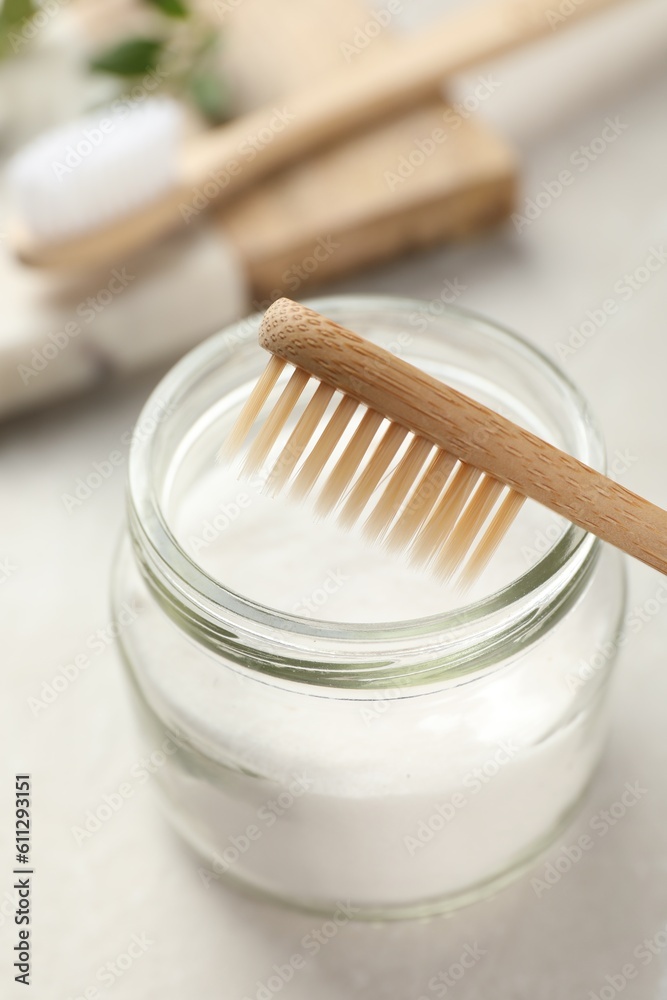 Bamboo toothbrush and jar of baking soda on table, closeup Bamboo toothbrush and jar of baking soda on table, closeup