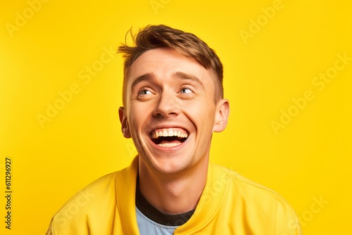 Headshot portrait photography of a satisfied boy in his 30s winking against a bright yellow background. With generative AI technology © Markus Schröder