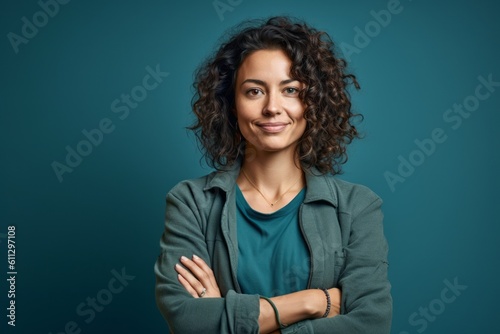 Medium shot portrait photography of a satisfied girl in her 30s crossing the arms against a teal blue background. With generative AI technology