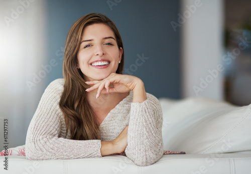 Portrait, happy and woman relax on couch in home living room on holiday. Face, smile or young female person from Canada on sofa in lounge, apartment or house to enjoy me time, vacation or break alone #611297753