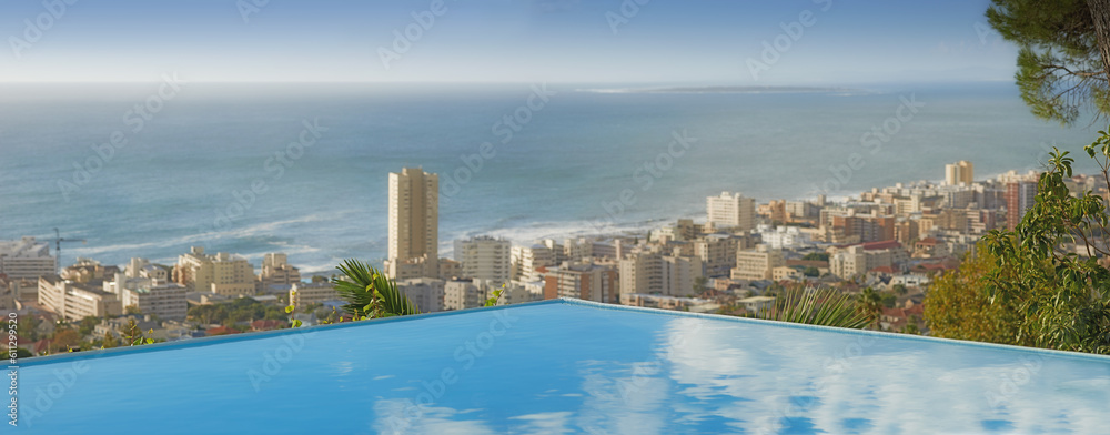 Fototapeta premium Travel, ocean and infinity pool in city on vacation and hotel view in Cape Town with nobody, buildings and urban beach property. Cityscape, sea and sky at luxury accommodation for summer holiday trip