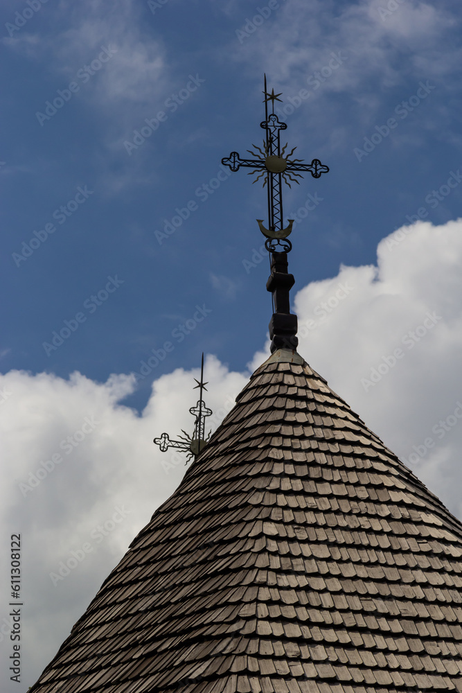 old wooden church against the blue sky in Ukraine, wooden roof with a cross old wooden church against the blue sky in Ukraine, wooden roof with a cross
