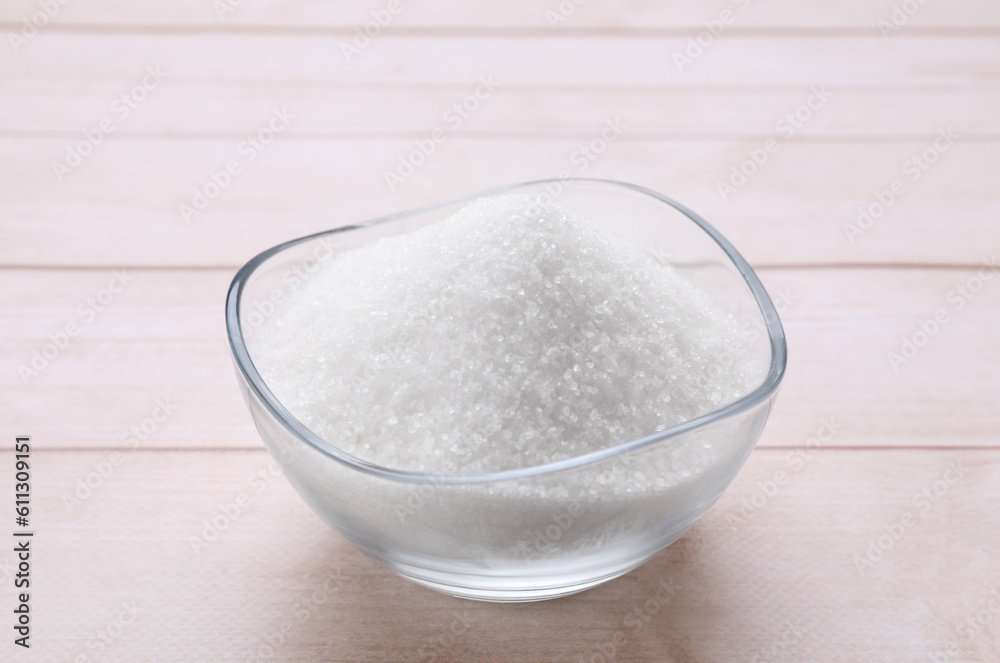 Granulated white sugar in bowl on wooden table, closeup Granulated white sugar in bowl on wooden table, closeup