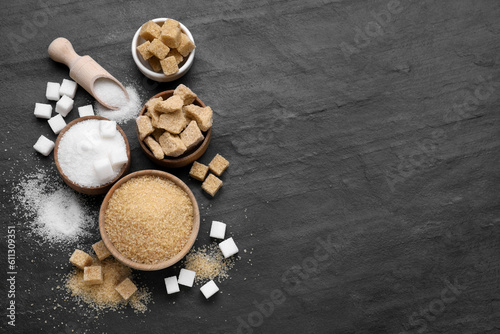 Different types of sugar on black table, flat lay. Space for text