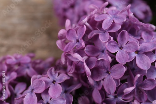 Fototapeta Naklejka Na Ścianę i Meble -  Beautiful lilac flowers on wooden table, closeup
