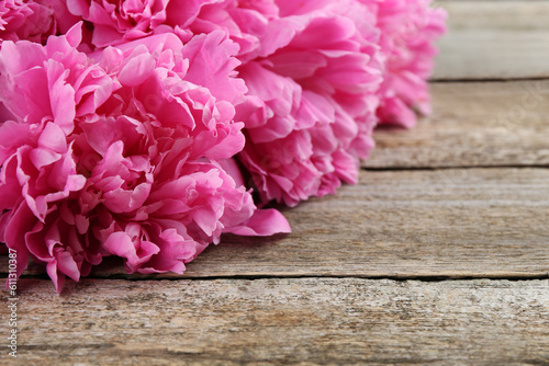 Beautiful pink peonies on wooden table, closeup. Space for text © New Africa