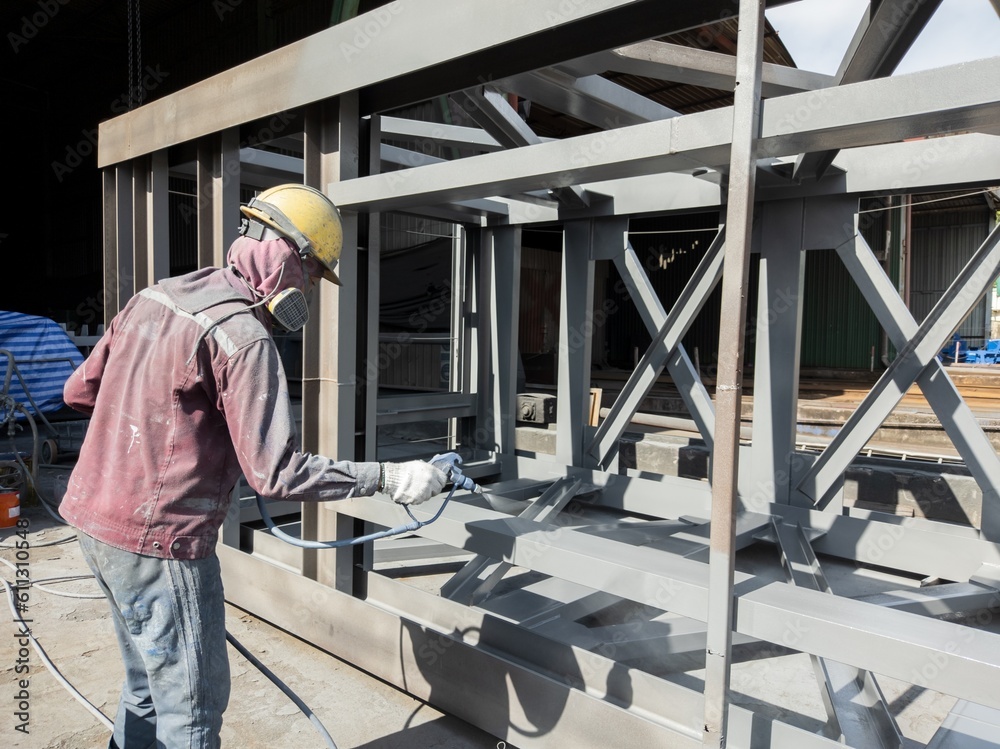 Painters are painting topcoat on the side of the steel beam to achieve the desired thickness.