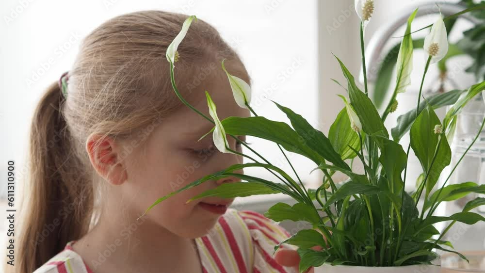 Girl with flowers. Portrait of a child in the home garden. Beautiful cute child takes care of plants in the home greenhouse. Plant care. Home gardening concept. Girl with flowers. Portrait of a child in the home garden. Beautiful cute child takes care of plants in the home greenhouse. Plant care. Home gardening concept.