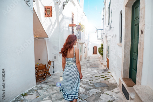 A young girl walks the streets of the historic white town of Ostuni in the Italian region of Puglia