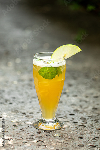 Glass of refreshing iced tea with mint and apple in the garden 