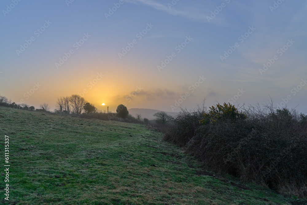 A photograph of a hazy sunrise as seen from Brading Downs on the Isle of Wight