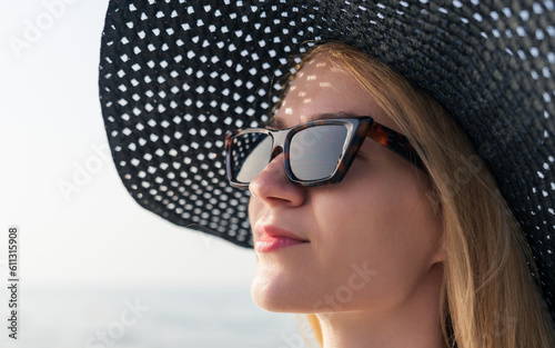 Portrait of a young woman in a summer dress and hat during a summer vacation