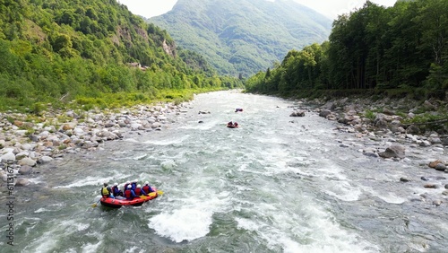 Go rafting on the river with dinghies immersed in the rapids of the stream and the nature of the canyon in Val Sesia Alagna Piedmont Alps mountains - drone view of summer water sport activities  photo