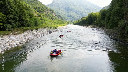 Go rafting on the river with dinghies immersed in the rapids of the stream and the nature of the canyon in Val Sesia Alagna Piedmont Alps mountains - drone view of summer water sport activities  © andrea